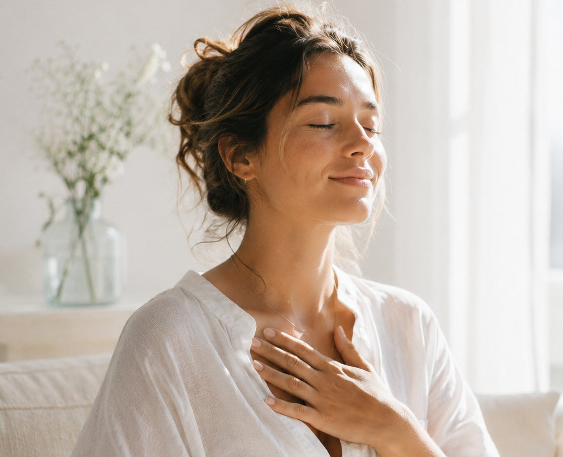 Woman with hands on her heart in a calm bright room, therapeutic wellness
